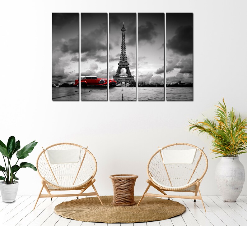 Puede incluir: Una impresi&oacute;n en lienzo en blanco y negro de la Torre Eiffel en Par&iacute;s, Francia. Un coche rojo vintage est&aacute; aparcado frente a la torre. La impresi&oacute;n est&aacute; dividida en cinco paneles.