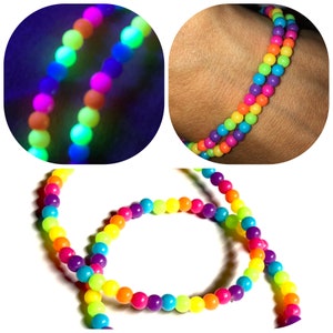 May include: A selection of vibrant beaded necklaces. The beads display a rainbow of colours, including pink, orange, yellow, green, and blue. Some images show the beads glowing under a black light.