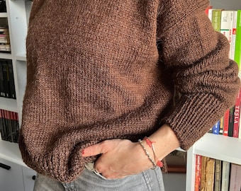 May include: A brown turtleneck sweater with a loose fit and long sleeves.