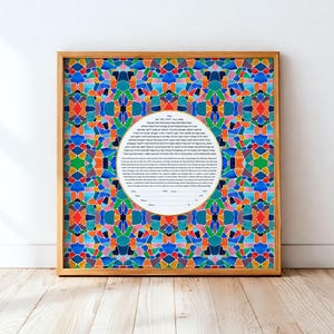 May include: A framed artwork with a colorful mosaic pattern in shades of blue, green, orange, and red. The artwork features a central oval with text, set within a natural wood frame. The artwork is displayed against a white wall.