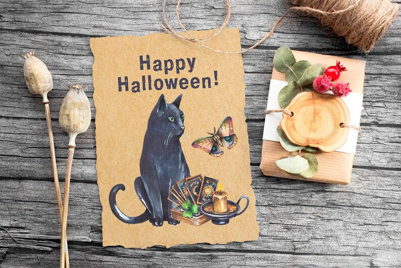 Pu&ograve; includere: Un biglietto marrone con il testo "Happy Halloween!" e un gatto nero seduto accanto a una candela e carte dei tarocchi. Una farfalla vola sopra il gatto.