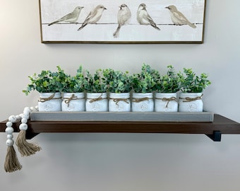 Centro de mesa rústico con tarro de cristal y vegetación