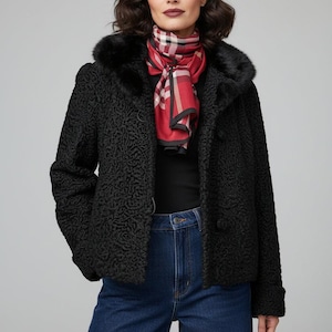 May include: A black textured coat with a fur collar and a red and black plaid scarf. The coat has a button-up front and is paired with blue jeans. The overall style is classic and elegant.