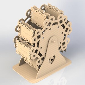 May include: A light brown, laser-cut wooden Ferris wheel photo display. The wheel has three photo holders with the word "PHOTO" on each. The base features a heart-shaped cutout. The design is intricate and decorative.
