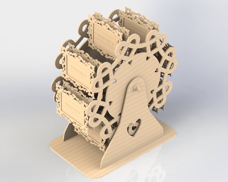 May include: A light brown, laser-cut wooden Ferris wheel photo display. The wheel has three photo holders with the word "PHOTO" on each. The base features a heart-shaped cutout. The design is intricate and decorative.