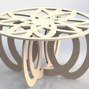 May include: A light-colored, wooden coffee table with a decorative, openwork design on the tabletop. The table has a round top and curved legs, creating a modern and artistic look. The table is approximately 24 inches in diameter.