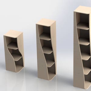 Könnte beinhalten: Drei hellfarbene Holzregale in verschiedenen Höhen. Jedes Regal hat ein einzigartiges, geschwungenes Design mit mehreren offenen Regalböden. Die Regale sind ideal für die Präsentation von Gegenständen in einem Haus oder Einzelhandelsgeschäft.