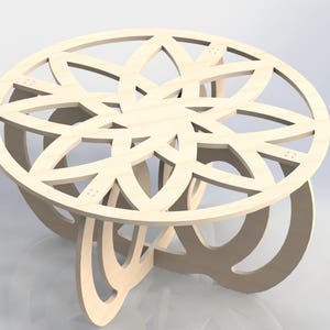 May include: A light-colored wooden coffee table with a circular top featuring a floral-like cutout design. The table has a unique base with curved supports. The table is approximately 30 inches in diameter.