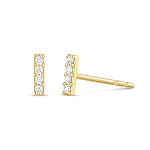 May include: A pair of gold bar stud earrings with five small clear diamonds set in each bar.