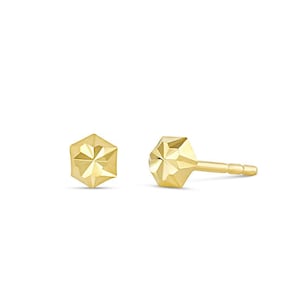 May include: A pair of gold-toned geometric stud earrings. Each earring features a faceted, hexagonal shape.