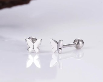 May include: A pair of silver butterfly stud earrings. The earrings have a small butterfly design and a ball post.