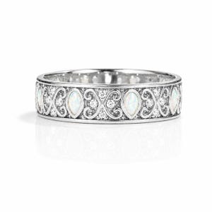 May include: A silver ring with an intricate design. The ring features alternating oval-shaped white stones and small round clear stones, set within a detailed filigree pattern. The ring's band is approximately 0.25 inches wide.