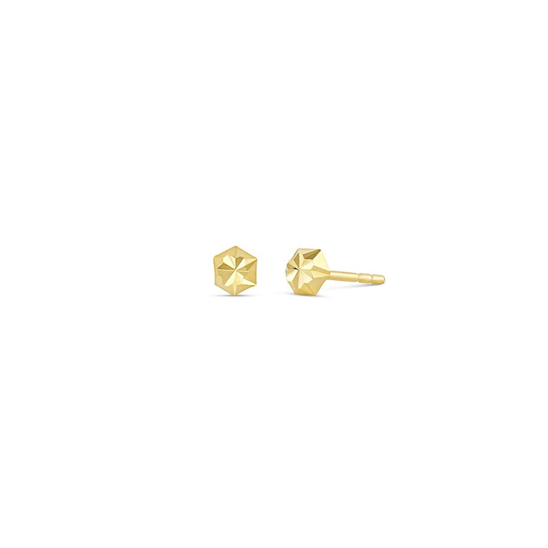 May include: A pair of gold-toned geometric stud earrings. Each earring features a faceted, hexagonal shape.