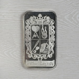 1974 Father&#39;s Day 1 Troy Ounce .999 Fine Silver Art Bar MADISON MINT depicting Coat of Arms Seal with Tennis, Bowling, Baseball and Fishing