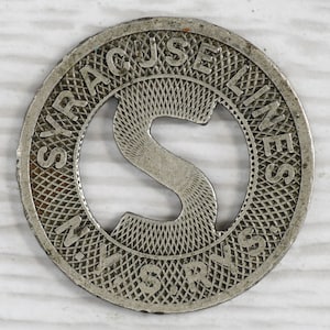 May include: A silver metal token with the words "Syracuse Lines" and "N.Y.S.R.Y.S." around the edge. The center of the token has a large letter "S" cut out.