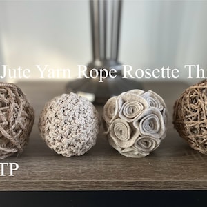 K&ouml;nnte beinhalten: Vier dekorative Kugeln aus Jutegarn, Wolle und Stoffrosetten. Die Kugeln sind in einer Reihe auf einer Holzoberfl&auml;che angeordnet. Der Text "Thick Jute Yarn Rope Rosette Thin Jute" befindet sich &uuml;ber den Kugeln, und der Text "MCITP" befindet sich unter den Kugeln.