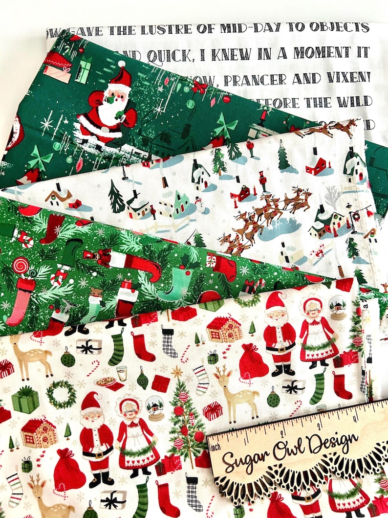 May include: A collection of Christmas-themed fabric patterns. Designs include Santa Claus, reindeer, stockings, and holiday text on a white and green background. A wooden ruler with the text "Sugar Owl Design" is also visible.