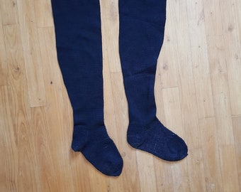 May include: A pair of black knee-high socks with a ribbed texture and a metal clip at the top.
