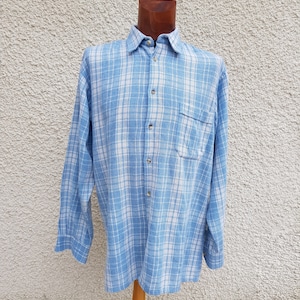 May include: A blue and white checked long-sleeved shirt with a button-down collar and a single pocket on the left chest.