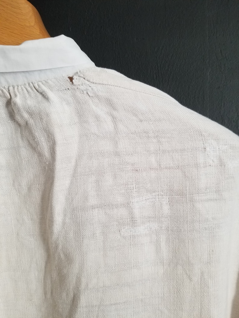May include: A white linen shirt with a small hole near the collar.