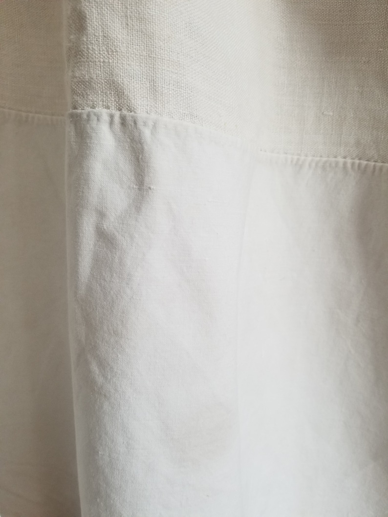 May include: White linen fabric with a textured weave. The fabric is sewn together with a seam.