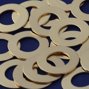 May include: A pile of gold-colored metal washers. The washers are arranged in a random pattern on a blue background.