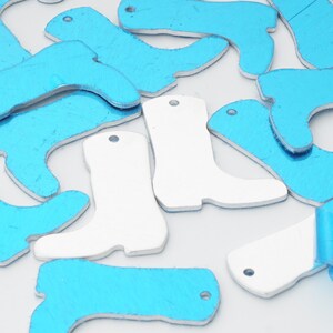 May include: A collection of blue and white metal boot charms. The charms are shaped like cowboy boots and have a hole at the top for hanging.