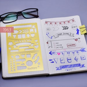 May include: A gold stencil with various shapes and designs, including arrows, hearts, stars, and banners. The stencil is labeled "WEEKEND" and "tibetara".