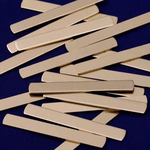 Peut inclure: Un tas de bandes de métal couleur or, disposées de manière aléatoire sur un fond bleu foncé.