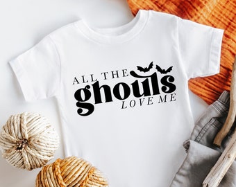 Könnte beinhalten: Ein weißer Baby-Strampler mit schwarzem Text, der "All the ghouls love me" lautet, und zwei schwarzen Fledermäusen über dem Text.