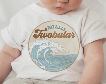 May include: A white baby onesie with a blue and brown graphic of a wave and the text "Totally Twobular".