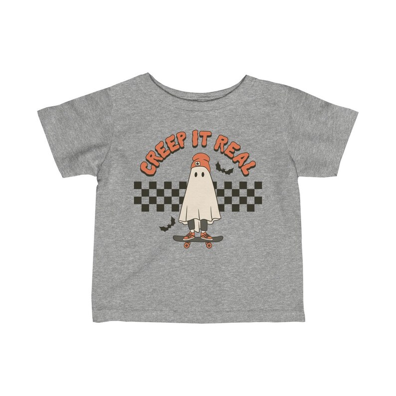 May include: A gray t-shirt with a ghost wearing a beanie and skateboarding. The text "CREEP IT REAL" is above the ghost.