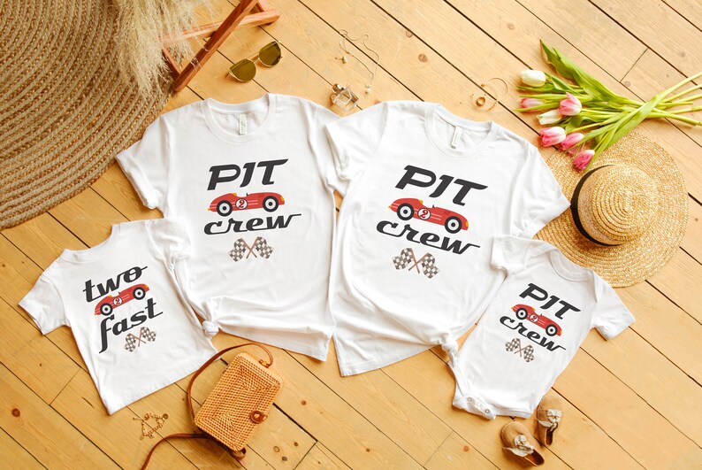 May include: Four white t-shirts with a red race car graphic and the text "PIT crew" and "two fast".