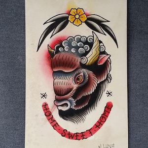 May include: A traditional tattoo flash design featuring a brown and black buffalo head with a yellow horn and a red background. The buffalo head is surrounded by a black and green floral design with a yellow flower. The text "Home Sweet Home" is written in red around the buffalo head.