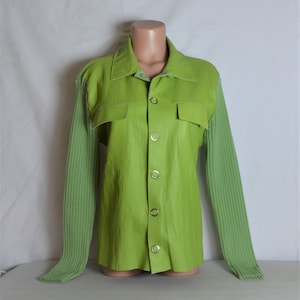 Pode incluir: Uma jaqueta de couro verde limão com mangas compridas. As mangas são feitas de um tecido de malha da mesma cor. A jaqueta tem um fecho de botões e dois bolsos com aba.
