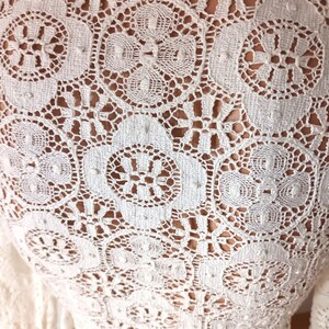 May include: White crochet fabric with a delicate floral pattern.