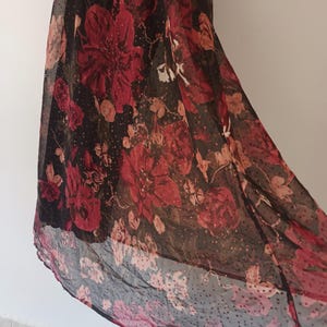 Peut inclure: Une jupe maxi noire en voile avec un imprim&eacute; floral rouge et un motif &agrave; pois.