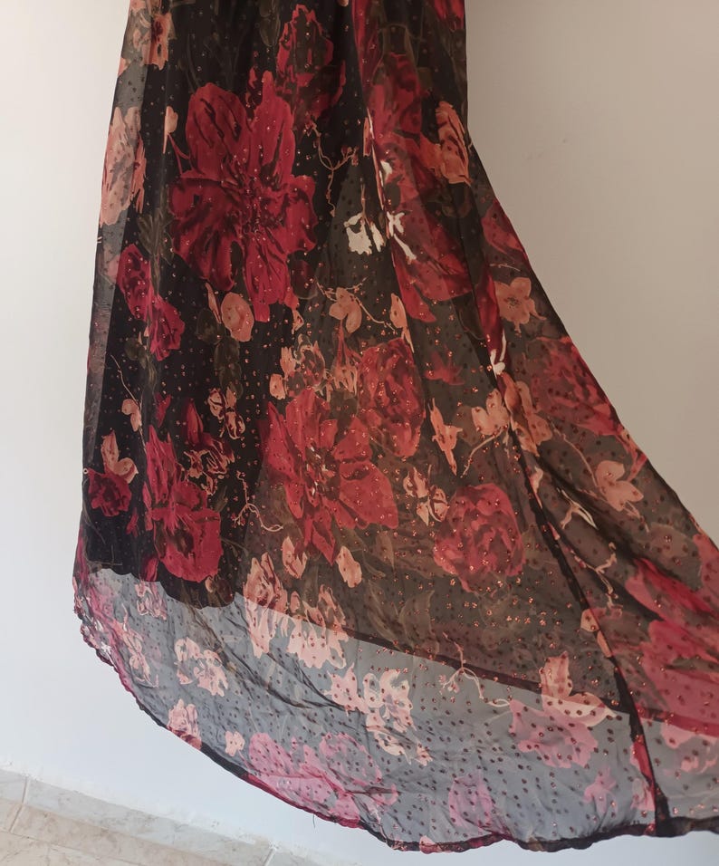 Peut inclure: Une jupe maxi noire en voile avec un imprim&eacute; floral rouge et un motif &agrave; pois.