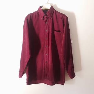 Op de afbeelding: Een lang mouw, bordeaux corduroy overhemd met een borstzak.