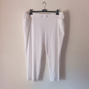 Pode incluir: Calça branca cropped com fecho de botão e bolsos laterais.