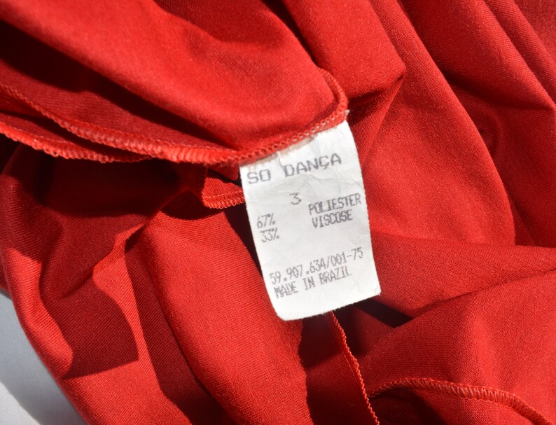 May include: Red fabric label with white text that reads "SO DAN&Ccedil;A", "3", "67% POLIESTER 33% VISCOSE", "59.907.634/001-75", and "MADE IN BRAZIL".
