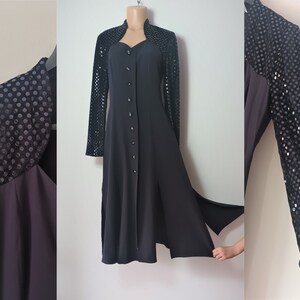 Könnte beinhalten: Ein schwarzes, langärmeliges Kleid mit einem Pailletten-Überzug. Das Kleid hat einen Knopfleisten vorne und einen Schlitz im Rock.