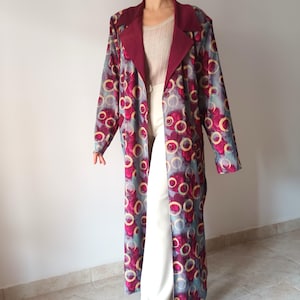 May include: A long, burgundy and blue patterned coat with a maroon collar. The coat has a button closure and a circle pattern.