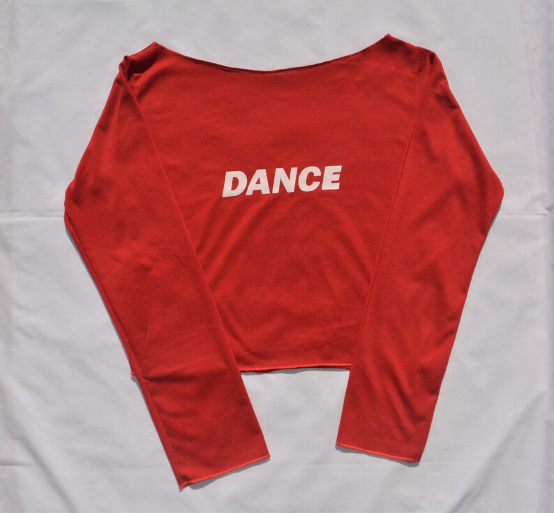 May include: A red long-sleeved shirt with a white "DANCE" graphic on the front.