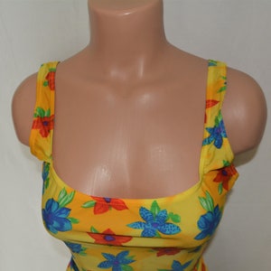 K&ouml;nnte beinhalten: Gelbes Tanktop mit einem Blumendruck mit blauen, roten und gr&uuml;nen Blumen.