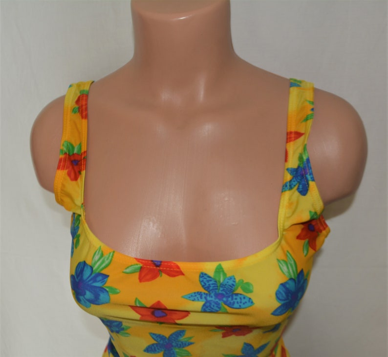 K&ouml;nnte beinhalten: Gelbes Tanktop mit einem Blumendruck mit blauen, roten und gr&uuml;nen Blumen.