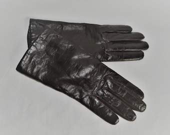 May include: A pair of brown leather gloves. The gloves are made of a textured leather and have a classic style.