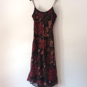 Peut inclure: Une robe midi &agrave; imprim&eacute; floral noir et rouge avec des bretelles fines et une jupe fluide.