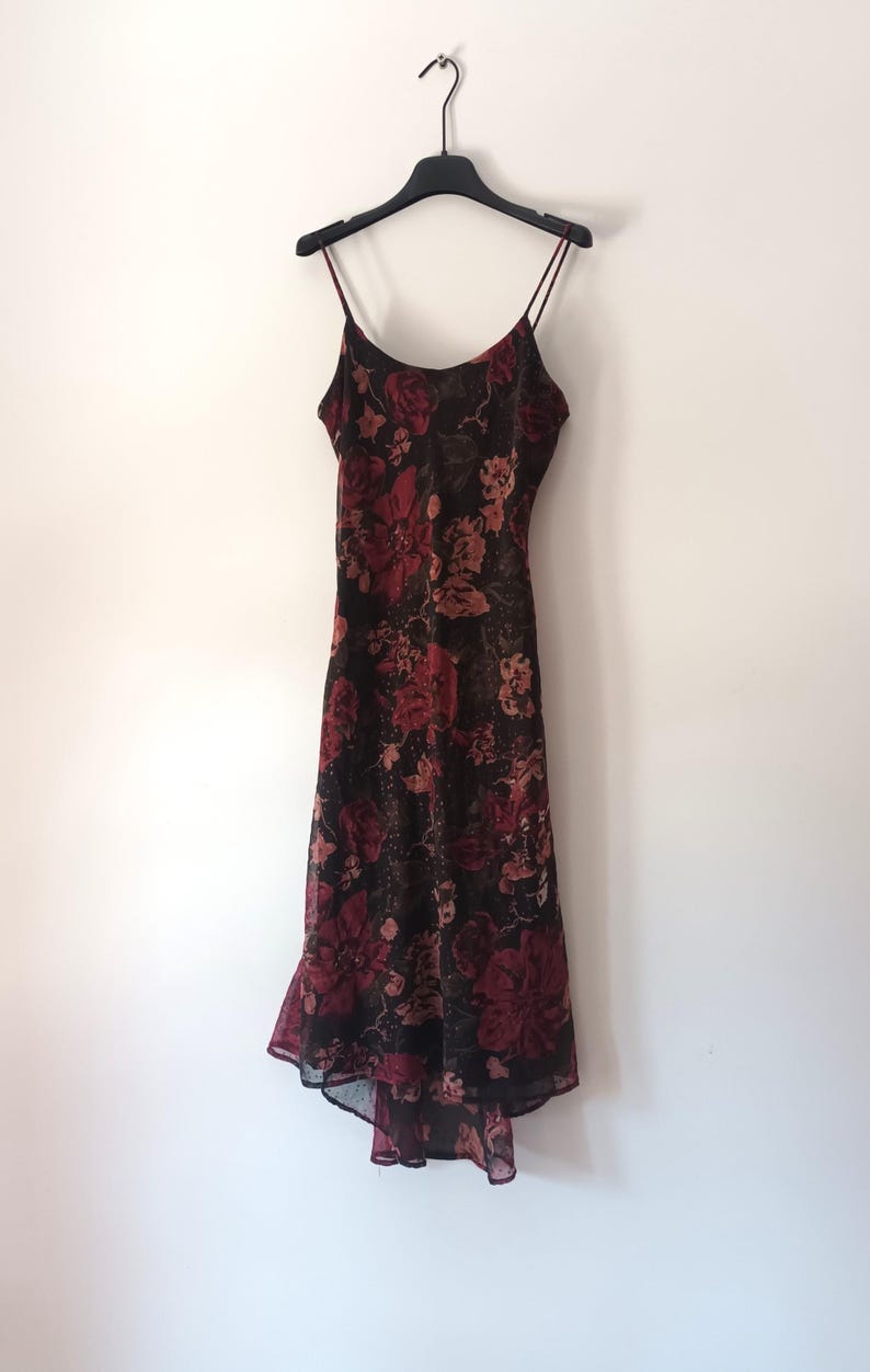 Peut inclure: Une robe midi &agrave; imprim&eacute; floral noir et rouge avec des bretelles fines et une jupe fluide.