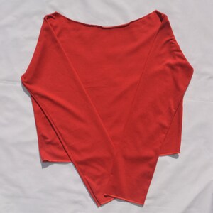 May include: A red long-sleeved shirt with a boat neck.
